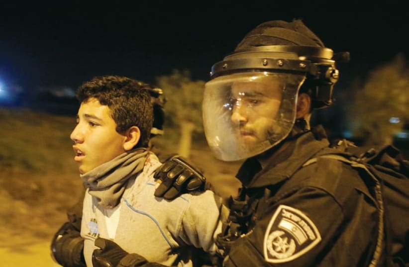 Police detain an Arab youth during clashes in the southern town of Rahat on January 20. (photo credit: REUTERS)