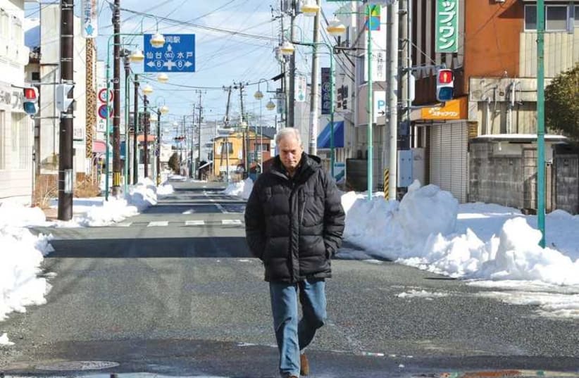 CBS NEWS correspondent Bob Simon walks through the town of Tomioka, Japan, three years after the 2011 Fukushima disaster. ( (photo credit: REUTERS)