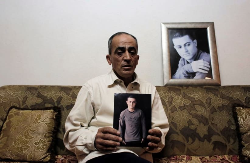 Said Musallam, an Israeli Arab whose son, Muhammad, is being held by Islamic State in Syria as an alleged spy, holds his photograph in his east Jerusalem home  (photo credit: REUTERS)