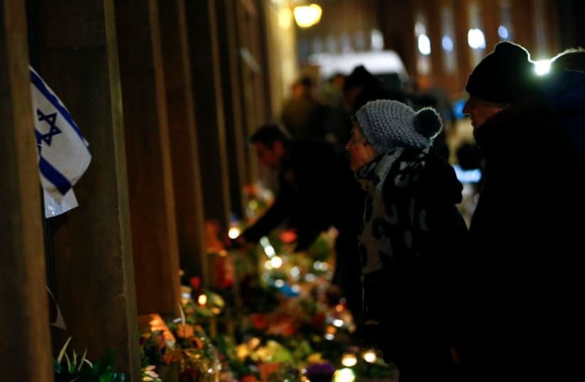 An Israeli flag at a memorial for the victims of the deadly attacks in front of the synagogue in Krystalgade in Copenhagen (photo credit: REUTERS)