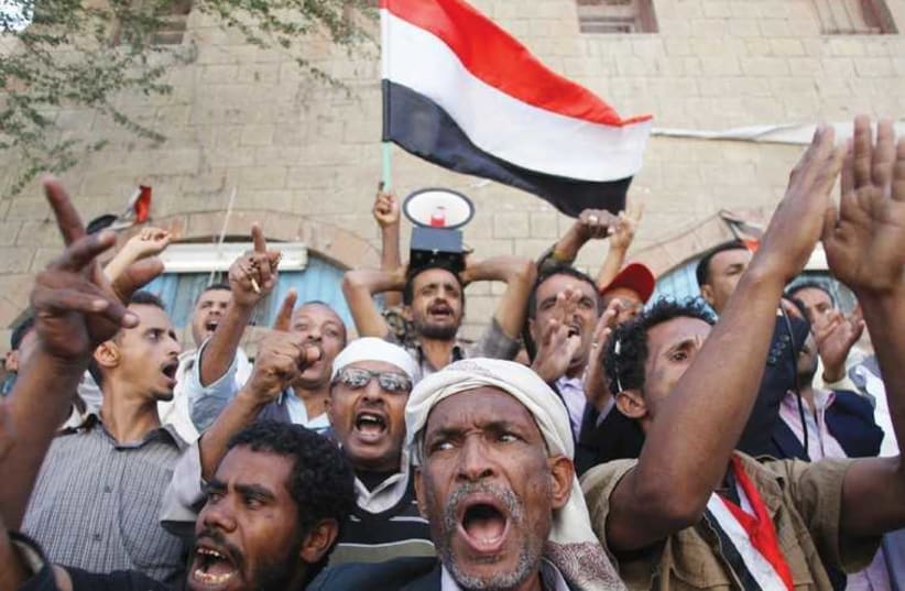 PROTESTERS SHOUT slogans against the Shi’ite Muslim Houthi movement, in the southwestern city of Taiz. (photo credit: REUTERS)