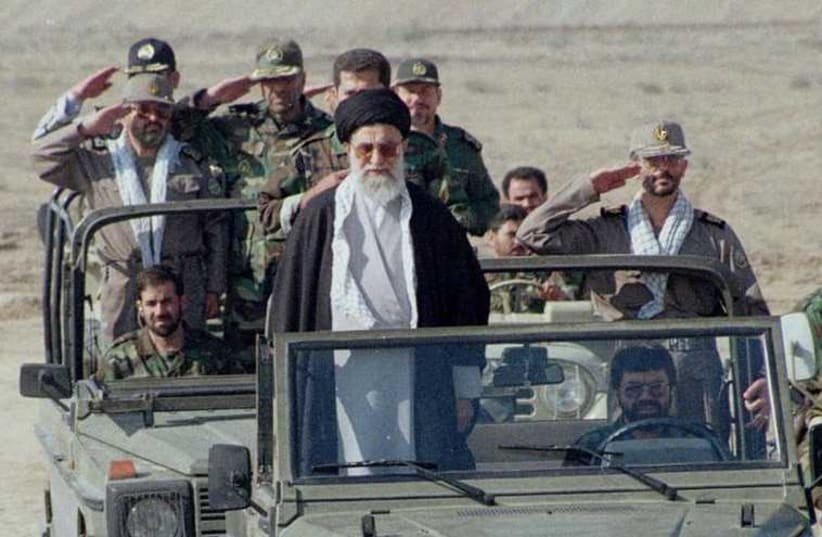 Iran's supreme leader, Ayatollah Ali Khamenei, stands in front of a jeep as he inspects 110,000 hardline Basij militia voluteers (photo credit: REUTERS)