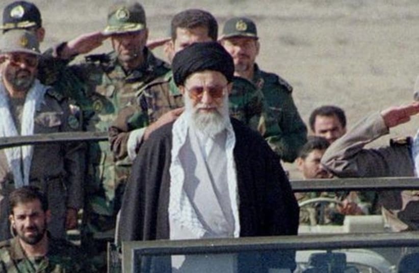 Iran's supreme leader, Ayatollah Ali Khamenei, stands in front of a jeep as he inspects 110,000 hardline Basij militia voluteers (photo credit: REUTERS)