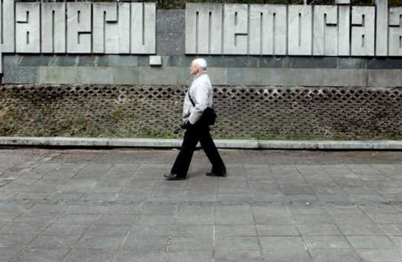 A man walks past a sign at a commemoration place during the March of the Living to honor Holocaust victims in Paneriai near Vilnius, Lithuania (photo credit: REUTERS)
