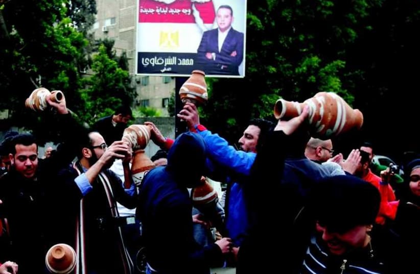 Des Egyptiens en colère cassent de la poterie lors d'une manifestation devant l'ambassade qatarie du Caire, le 21 février dernier. L'Egypte a, après le rappel de son ambassadeur, accusé le Qatar de soutenir le terrorisme  (photo credit: REUTERS)