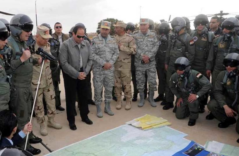 Egyptian President Abdel Fattah al-Sisi looks at a map during a meeting with pilots and crews specialists of the Egyptian Air Force near the border between Egypt and Libya (photo credit: REUTERS)