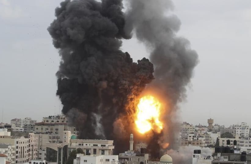 An explosion and smoke are seen after Israeli strikes in Gaza City (photo credit: REUTERS)