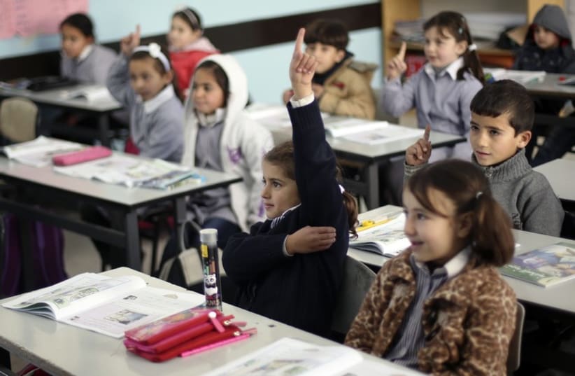 Palestinian first-graders sit with their schoolbooks during class in the West Bank city of Ramallah February 4, 2013. (photo credit: REUTERS)