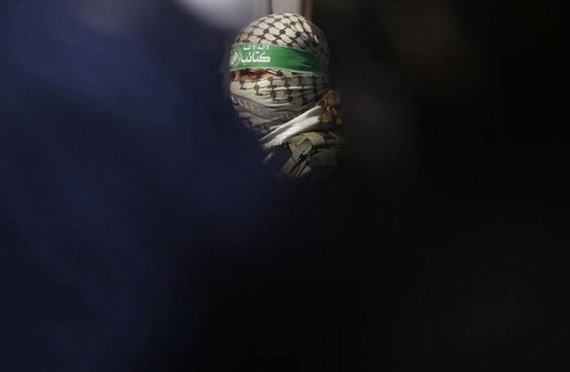 A Palestinian member of Hamas' armed wing takes part in a news conference (photo credit: REUTERS)