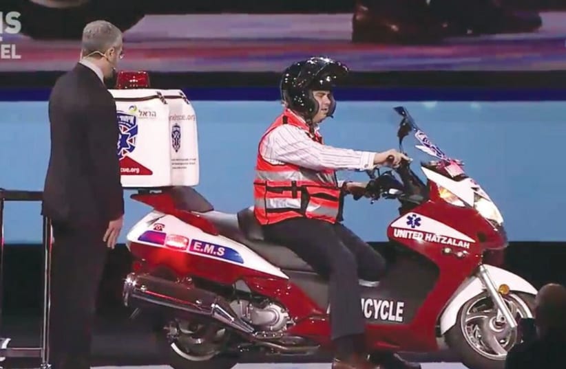 Eli Beer, the founder and president of United Hatzalah, arrives onstage on an ambucycle at the AIPAC conference in Washington (photo credit: UNITED HATZALAH‏)