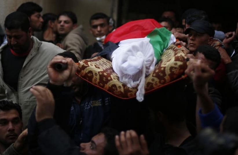 Mourners carry the body of Palestinian fisherman Tawfiq Abu Reyala, 34, whom medics said was killed by Israeli navy, during his funeral at Shatti refugee camp in Gaza City (photo credit: REUTERS)