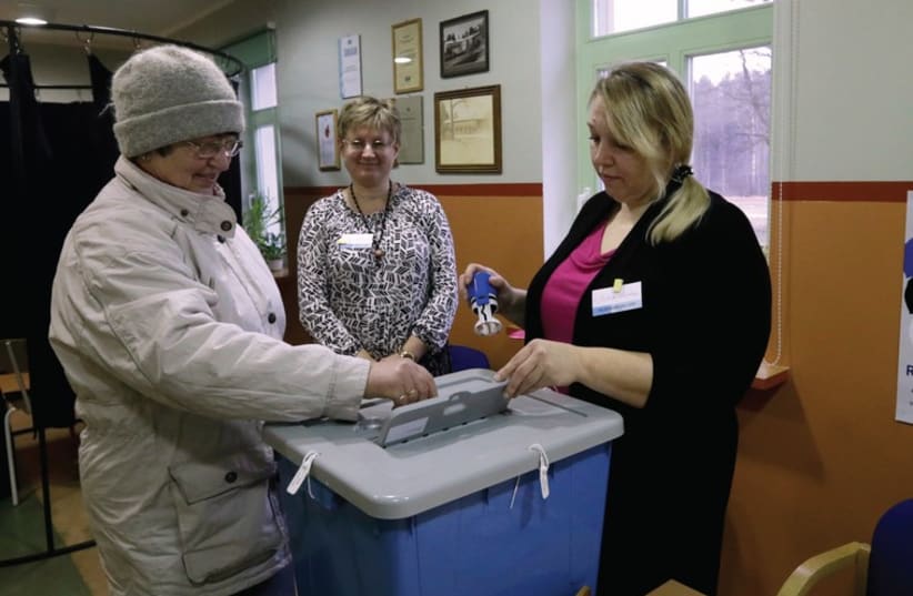 An Estonian citizen casts her vote during a parliamentary election in Uulu (photo credit: REUTERS)