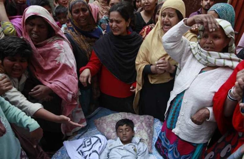  People mourn as they surround the body of their relative who was killed in a suicide attack on a church in Lahore  (photo credit: REUTERS)