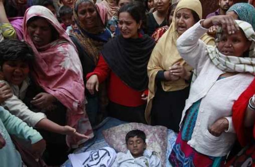  People mourn as they surround the body of their relative who was killed in a suicide attack on a church in Lahore  (photo credit: REUTERS)