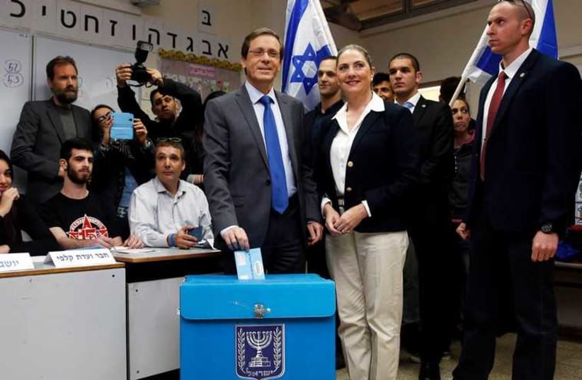 Issac Herzog votes in Tel Aviv accompanied by his wife, Michal. (photo credit: REUTERS)