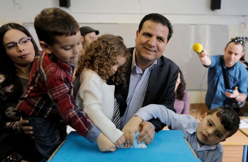 Ayman Odeh, head of the Joint Arab List, and his children cast his ballot (photo credit: REUTERS)