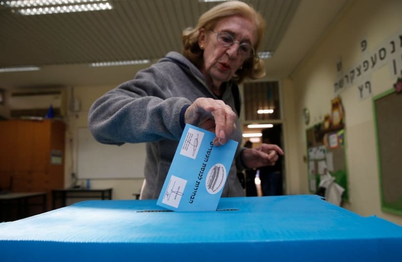 An Israeli casts her ballot for the parliamentary election at a polling station  (photo credit: REUTERS)