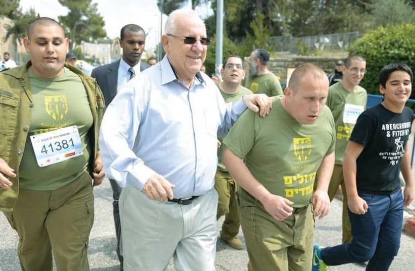 PRESIDENT REUVEN RIVLIN runs a stretch of the Jerusalem Marathon with Great in Uniform special-needs persons who have volunteered for the IDF (photo credit: MEIR ALFASSI)