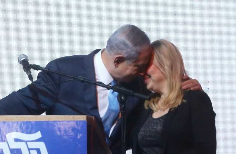 Prime Minister Benjamin Netanyahu (L) shares a moment with his wife, Sara, at Likud headquarters (photo credit: MARC ISRAEL SELLEM)