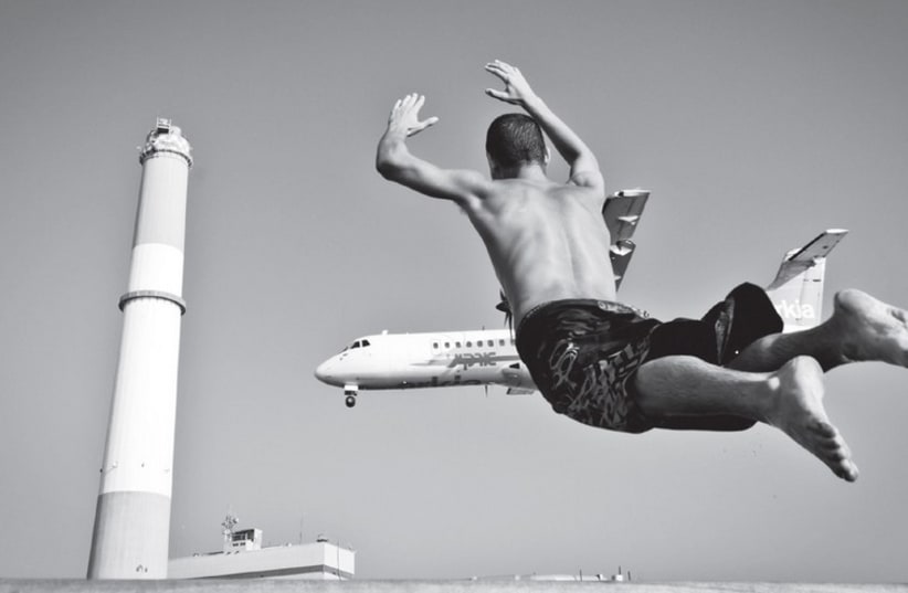 A flying man is contrasted with a plane in the sky. (photo credit: GABI BEN AVRAHAM)