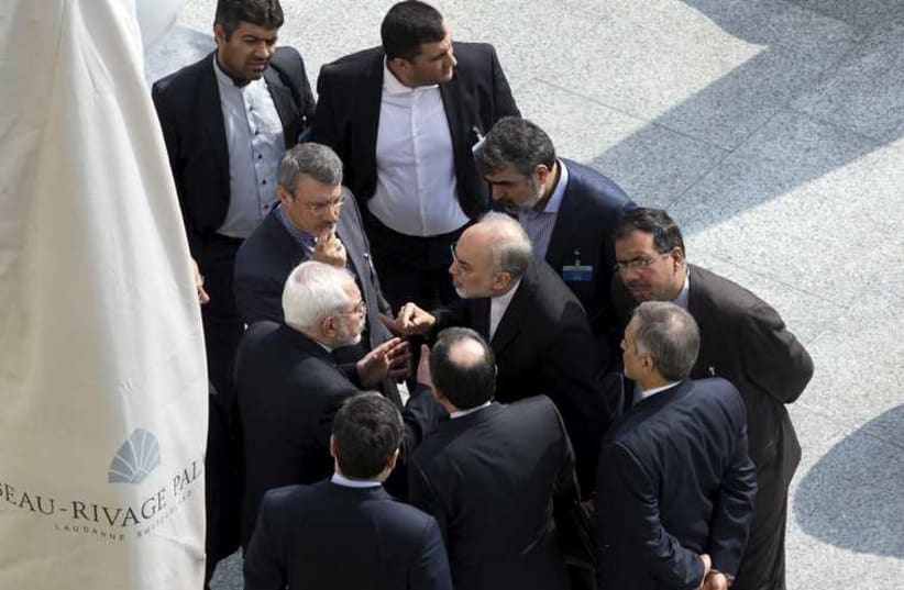 Iran's FM Zarif (C on left) and head of the AEO of Iran Salehi (C on right) with colleagues in Lausanne March 19,  2015  (photo credit: REUTERS)