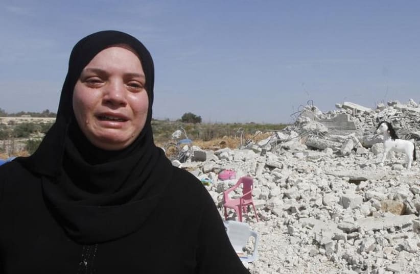 Palestinian woman Taghreed Sholi cries near the rubble of her house that was demolished by the IDF near Israel's controversial barrier in the village of Jarushiyya (photo credit: REUTERS)