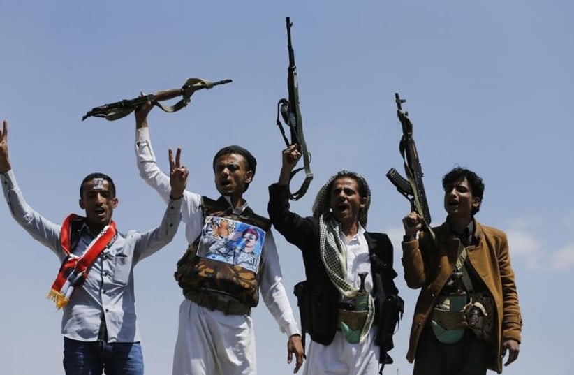 Supporters of Ahmed Ali Abdullah Saleh, the son of Yemen's former President Ali Abdullah Saleh, raise their rifles as they demonstrate in Sanaa (photo credit: REUTERS)