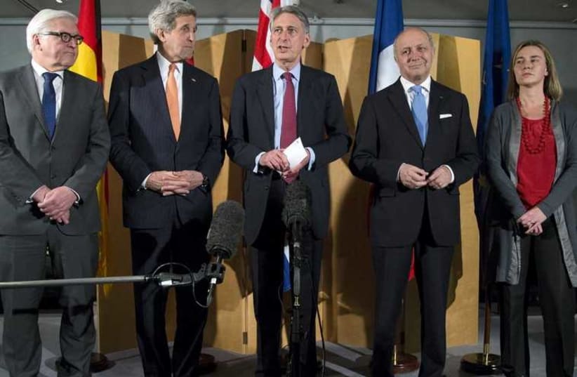 British Foreign Secretary Philip Hammond (C), flanked by German Foreign Minister Frank Walter Steinmeier (L), United States Secretary of State John Kerry (2nd L), French Foreign Minister Laurent Fabius (2nd R) and European Union High Representative Federica Mogherini, makes a statement about their m (photo credit: REUTERS)