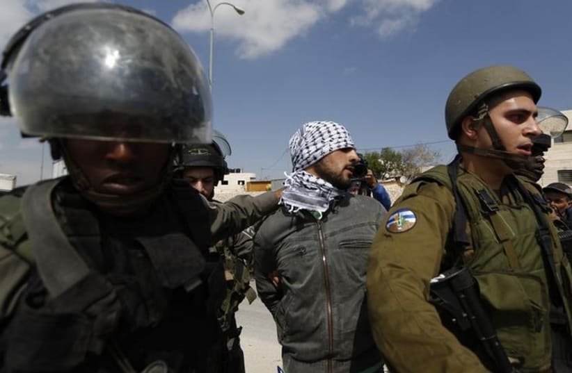 Israeli security forces detain a Palestinian near the West Bank town of Abu Dis (photo credit: REUTERS)