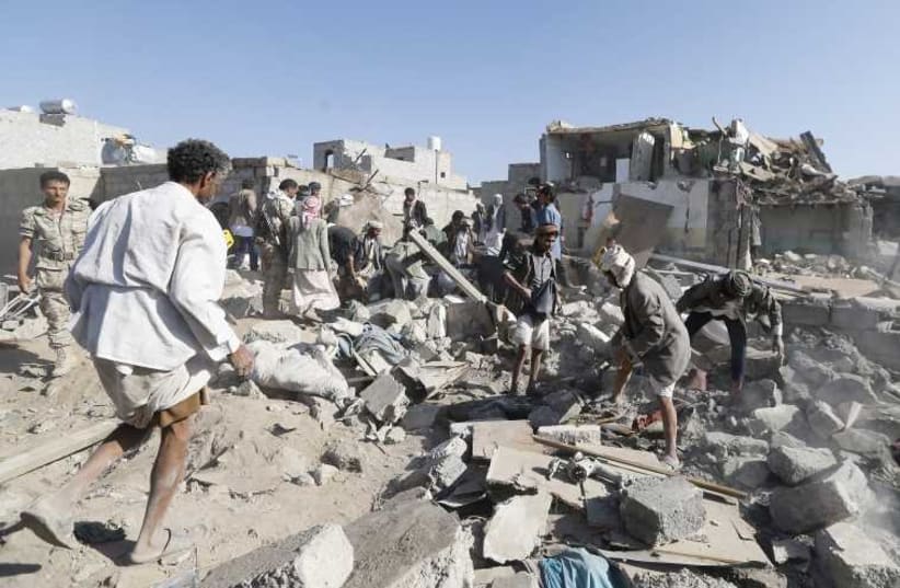 People search for survivors under the rubble of houses destroyed by an air strike near Sanaa Airport. (photo credit: REUTERS)