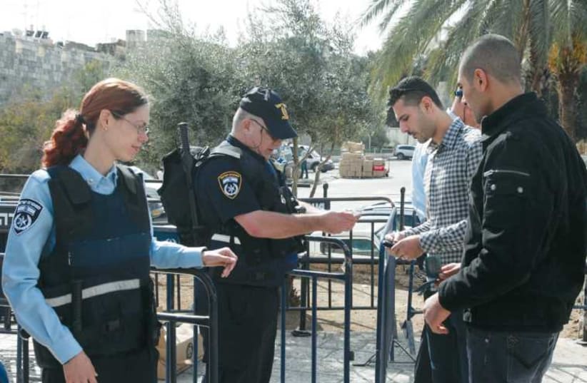 Border police check Palestinian IDs at the entrance to Jerusalem’s Old City. (photo credit: MARC ISRAEL SELLEM/THE JERUSALEM POST)