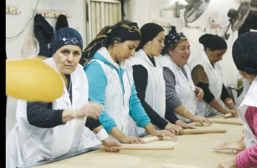 Women bake matzot in Jerusalem ahead of Passover. (photo credit: MARC ISRAEL SELLEM/THE JERUSALEM POST)