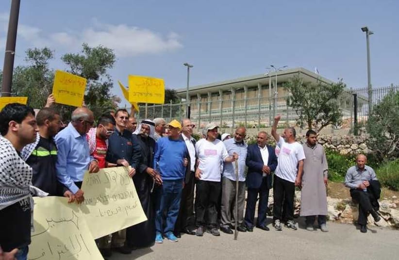 Ayman Odeh (center holding walking stick), head of the Joint List party, and his supporters stand outside the Knesset, March 29 (photo credit: SETH J. FRANTZMAN)