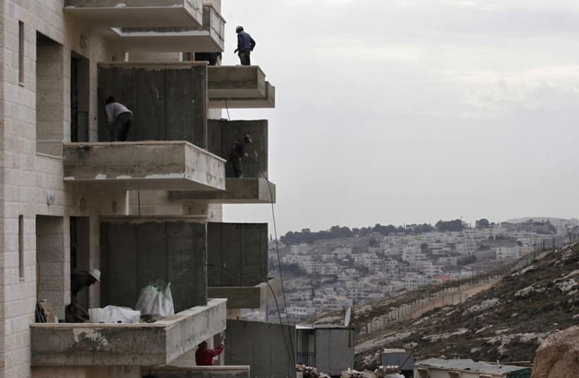 Laborers work at a construction site in Har Homa, near Jerusalem (photo credit: REUTERS)