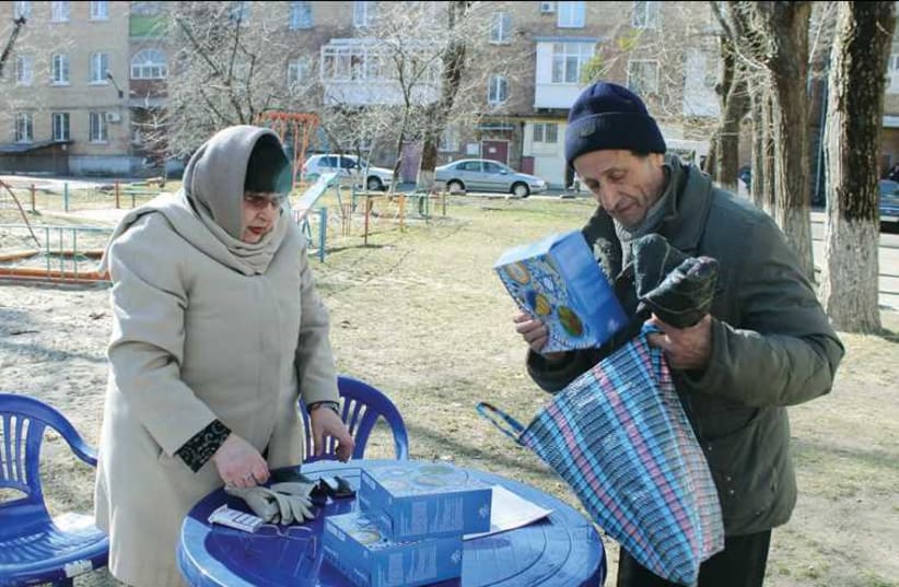 A JOINT Distribution Committee worker distributes matzot in Kiev last week. (photo credit: SAM SOKOL)