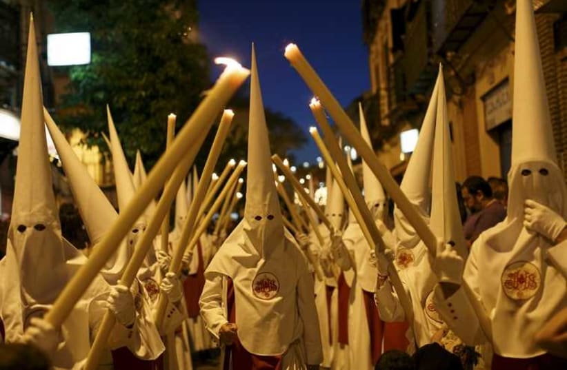 Penitents of the Siete Palabras (Seven Words) brotherhood make their penance during a Holy Week procession in the Andalusian capital of Seville, southern Spain (photo credit: REUTERS)