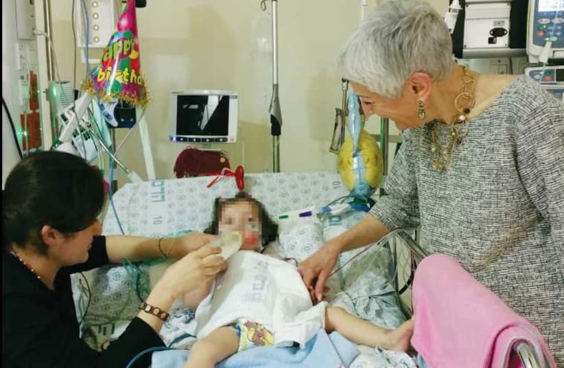 Lina Mansur takes care of her daughter Maryam while staying at Hadassah University Medical Center. (photo credit: BARBARA SOFER)