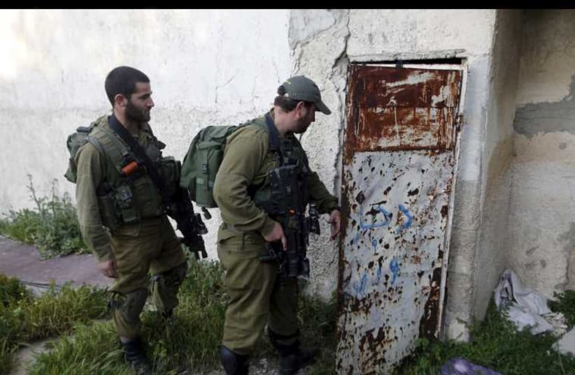 IDF soldiers search for a missing Israeli near the West Bank city of Hebron (photo credit: REUTERS)