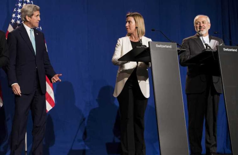 US Secretary of State John Kerry (L), EU High Representative Federica Mogherini (C) and Iranian Foreign Minister Javad Zarif (R)  make statements following nuclear talks in Switzerland (photo credit: REUTERS)