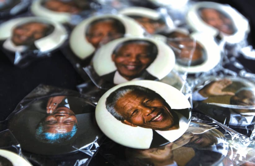 PINS DEPICTING former South African President Nelson Mandela are displayed for sale at a memorial service held by the African National Congress (photo credit: REUTERS)