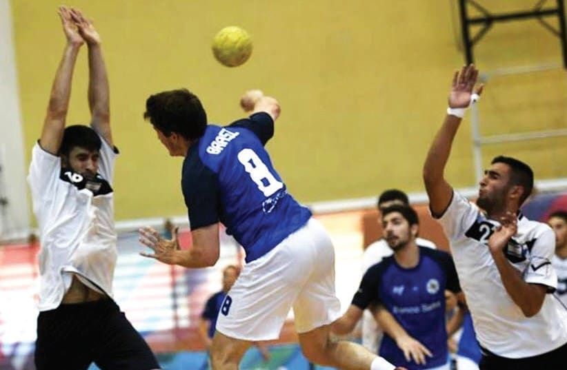 Israel’s handball team (in white) defeated Brazil 33-25 in the Maccabiah final on Friday.  (photo credit: AMIT SCHUSSEL)