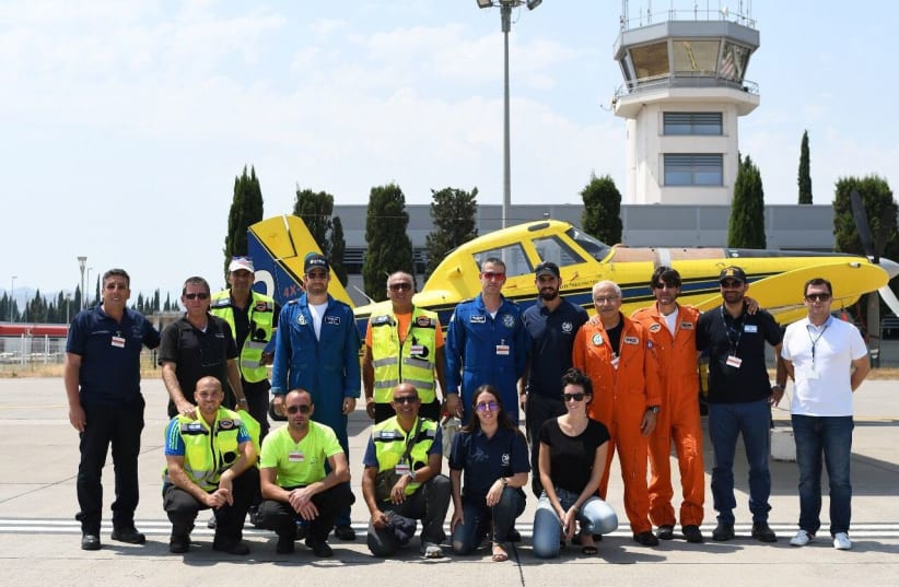 The Israeli delegation of firefighters pose in front of a plane in Montenegro. (photo credit: POLICE SPOKESPERSON'S UNIT)
