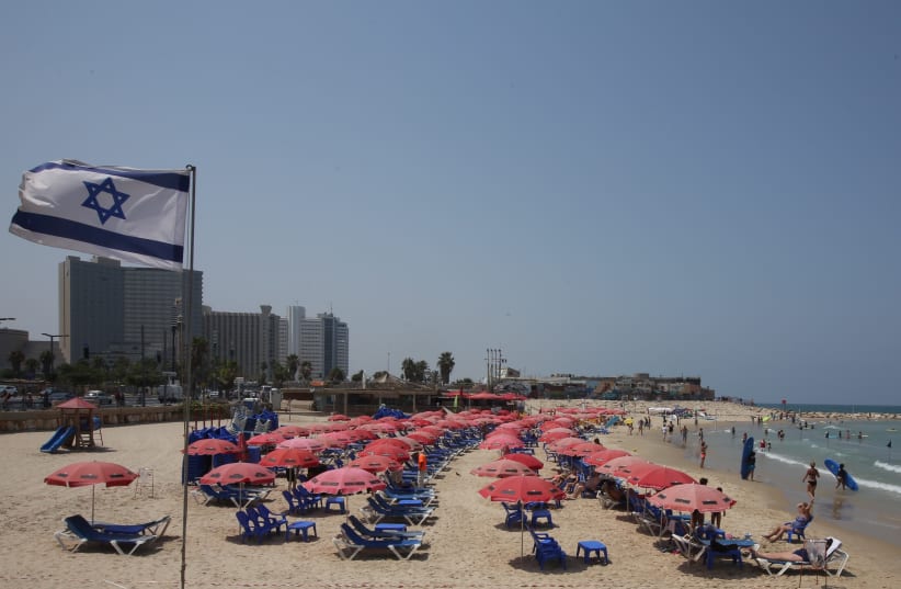 Israeli flag waving at a Tel Aviv beach. (photo credit: MARC ISRAEL SELLEM)