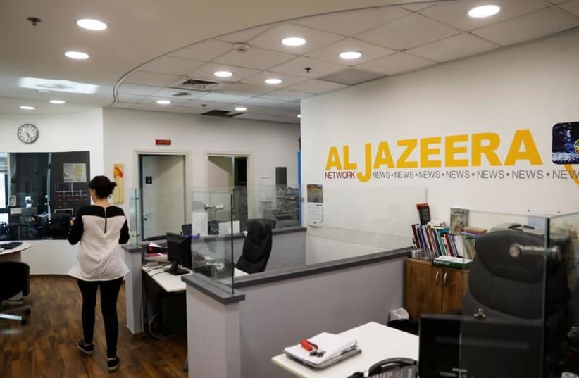 An employee walks inside an office of Qatar-based Al-Jazeera network in Jerusalem June 13, 2017.  (photo credit: REUTERS)