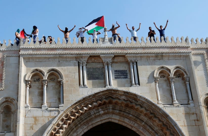 A Palestinian flag is waved at the Temple Mount in Jerusalem's Old City (photo credit: MUAMMAR AWAD/REUTERS)