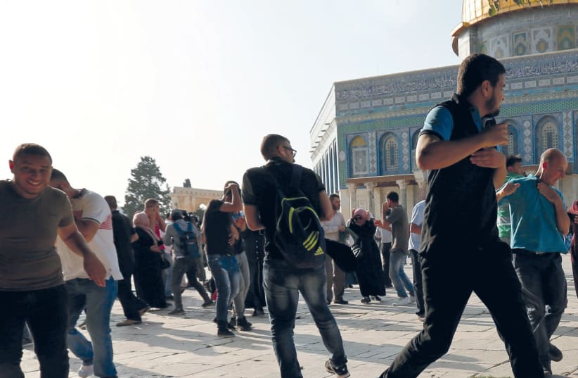 MUSLIM RIOTERS run as security personnel disperse them on the Temple Mount yesterday (photo credit: REUTERS)