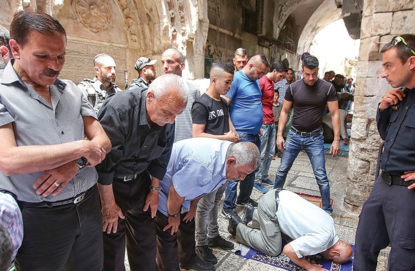 MUSLIMS BOYCOTTING the al-Aksa compound to protest metal detectors, even after they were dismantled, pray in Jerusalem’s Old City. (photo credit: MARC ISRAEL SELLEM/THE JERUSALEM POST)