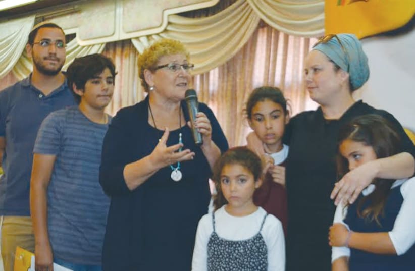 MIRIAM PERETZ, the mother of fallen Golani Brigade soldiers Uriel and Eliraz, speaks at the Colel Chabad ceremony yesterday, surrounded by her family. (photo credit: KAYLA STEINBERG)