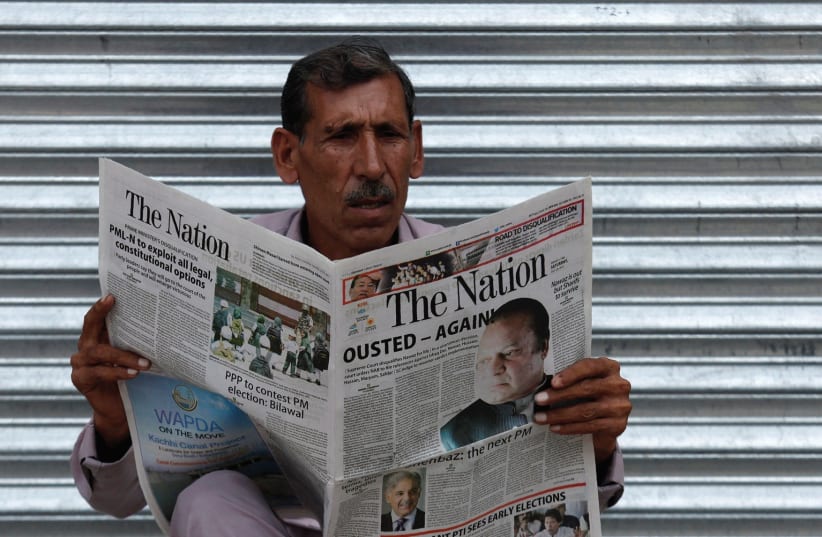 MAN in Pakistan reads a newspaper with news about the disqualification of Pakistani Prime Minister Nawaz Sharif by the Supreme Court.. (photo credit: REUTERS)