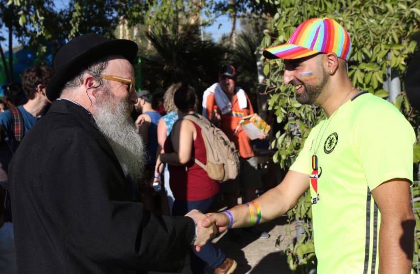 Jerusalem Gay Pride Parade participant shakes hands with a religious Jewish man (photo credit: MARC ISRAEL SELLEM)